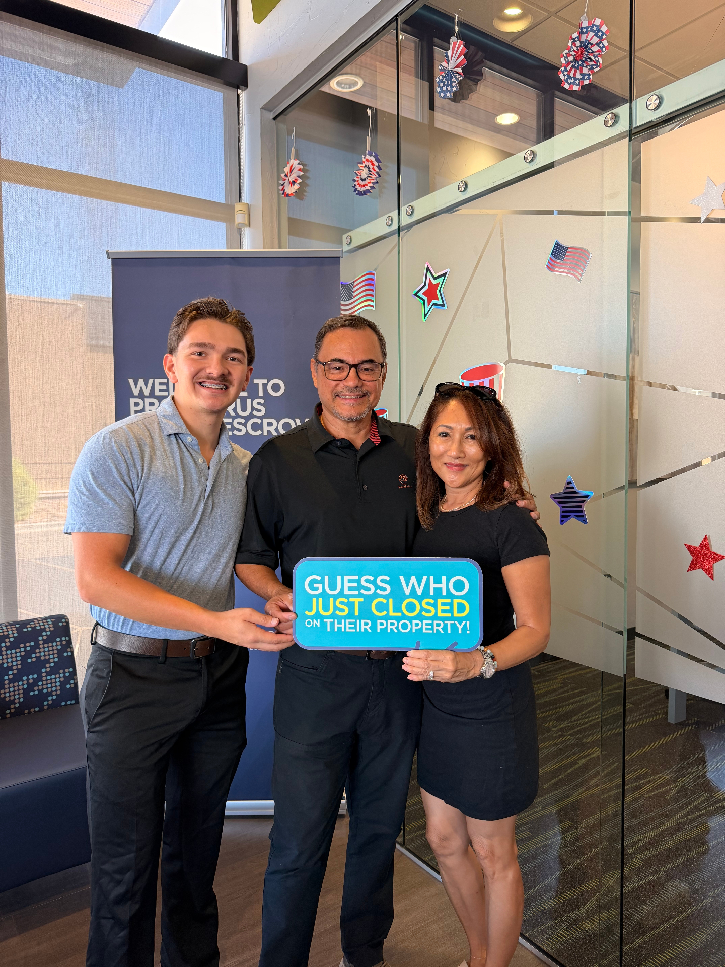 The Lightbourn Group celebrating a closing with military family clients holding a Just Closed sign